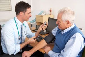 Doctor taking blood pressure senior man